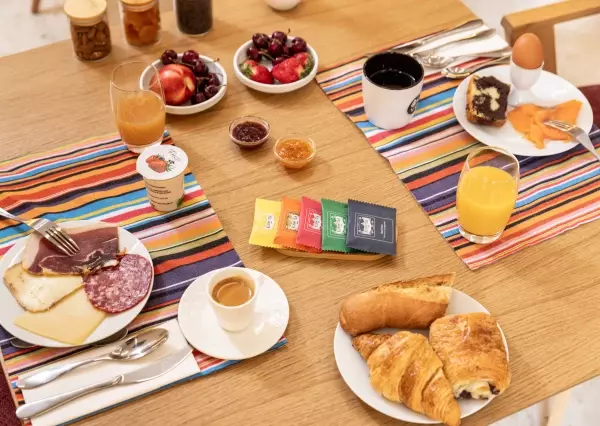 Healthy and appetizing breakfast buffet at OVYO Hotel Toulouse Centre, featuring a selection of golden pastries, fresh fruits, juices, coffee, and hot dishes.